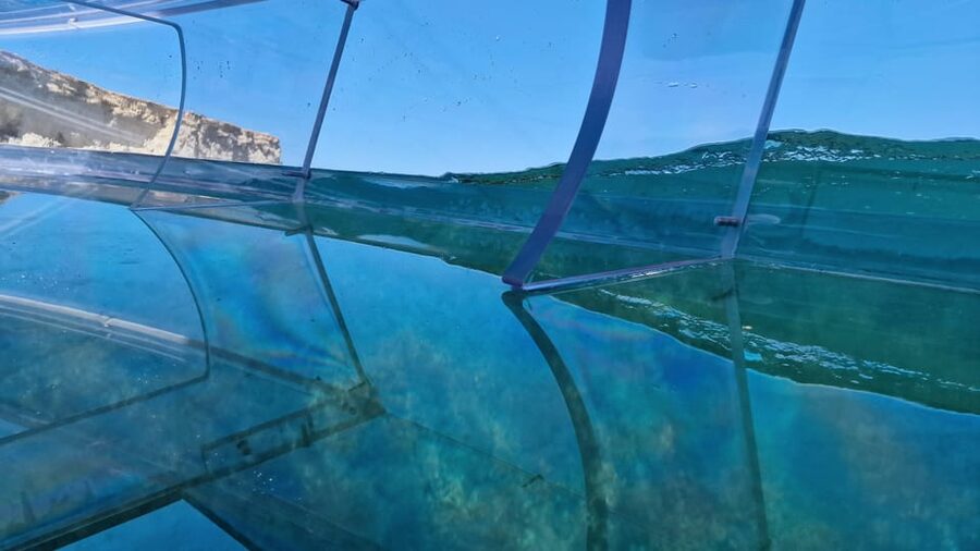 Syracuse: Coast and Sea Caves Full Transparent Boat Tour - Looking through the hull at the seabed